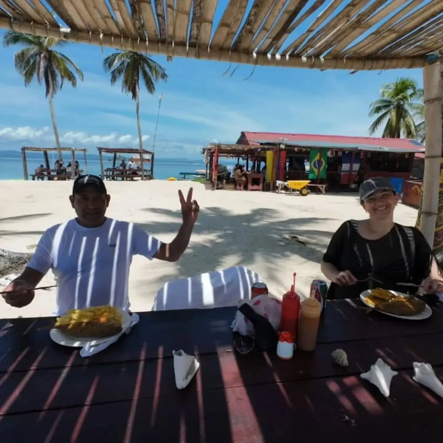 Two travelers smiling at a table during lunch on an island in Guna Yala