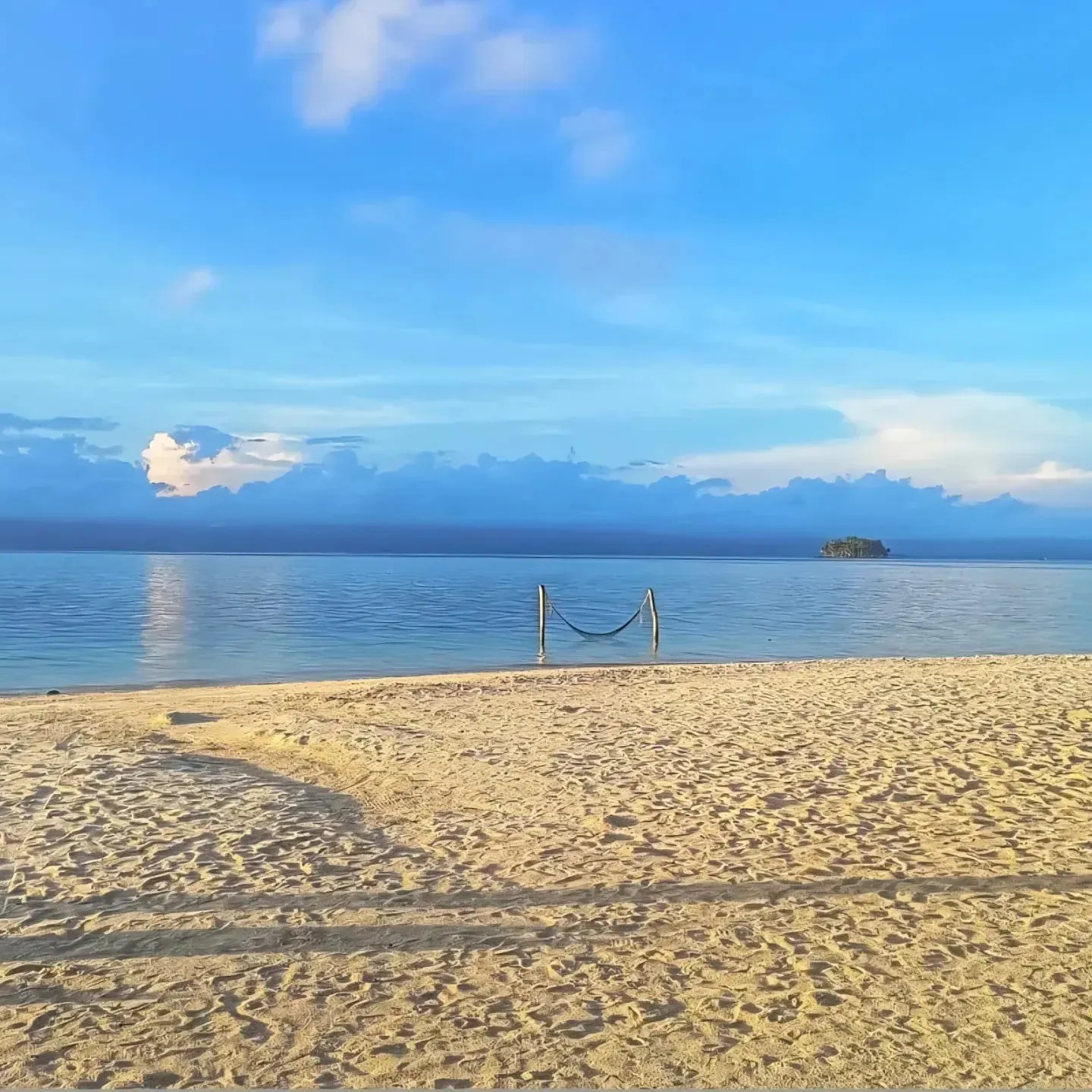 Un banco de arena clara y vacío que se funde con agua mansa y poco profunda bajo un cielo abierto en Guna Yala